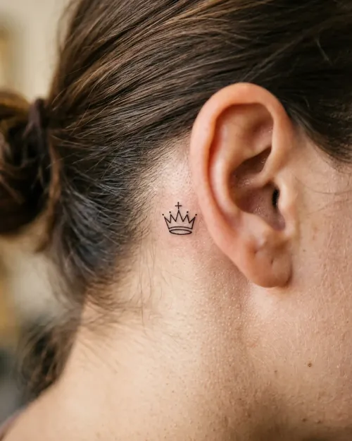 Winziges Schach-König-Kronen-Tattoo hinter dem Ohr, fotorealistische Nahaufnahme