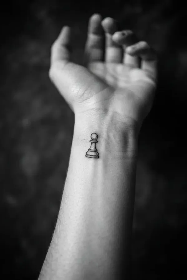 Black-and-white editorial shot of a wrist tattoo