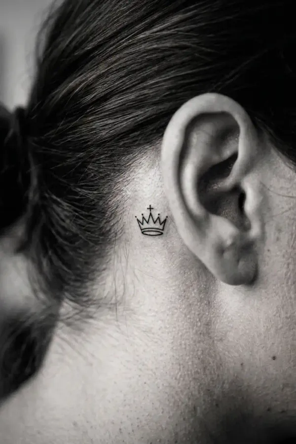 Black-and-white editorial shot of a behind-the-ear tattoo