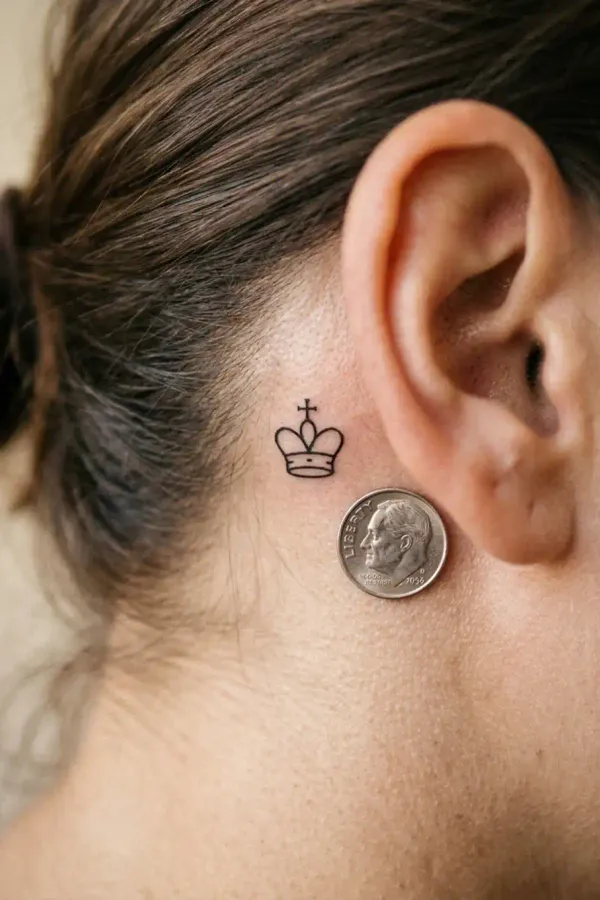 Size comparison: tiny behind-the-ear tattoo next to a coin